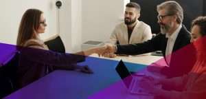 a woman shaking the hand a of a man across a table