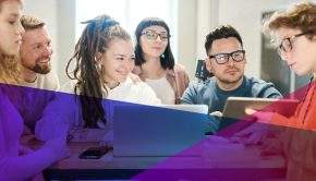 a group of young adults working together at a desk