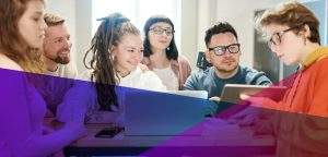 a group of young adults working together at a desk